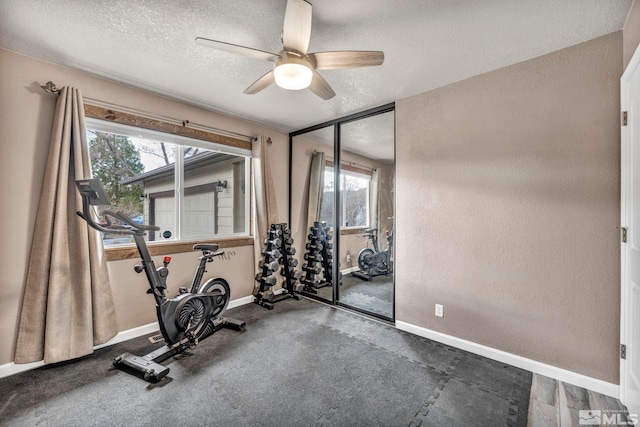 exercise area featuring ceiling fan, a textured ceiling, and a wealth of natural light