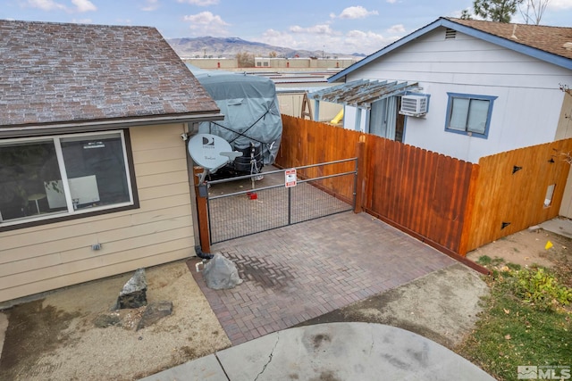 view of home's exterior with an AC wall unit and a mountain view