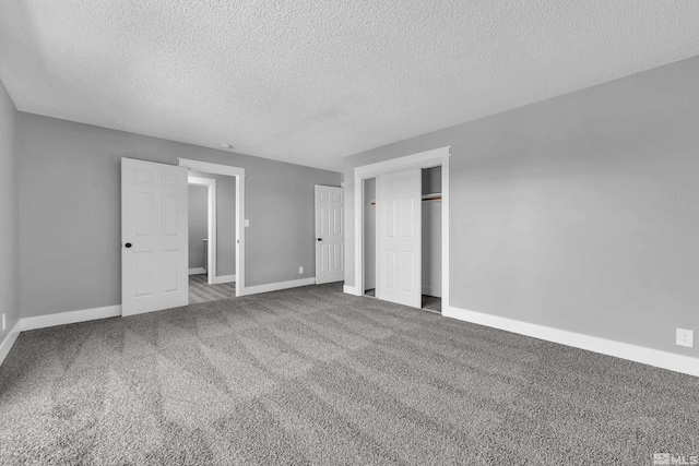 unfurnished bedroom with a textured ceiling and carpet floors