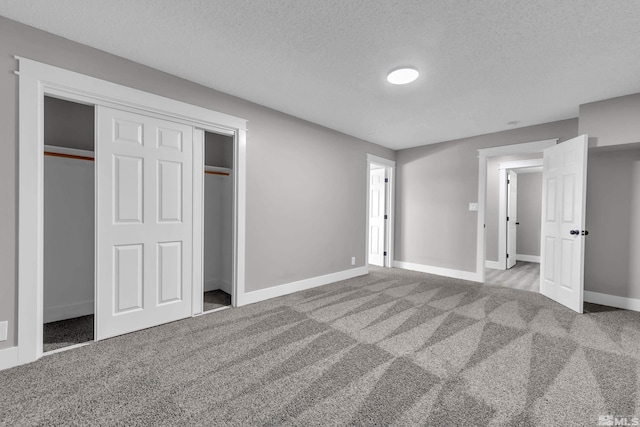 unfurnished bedroom with a closet, light colored carpet, and a textured ceiling