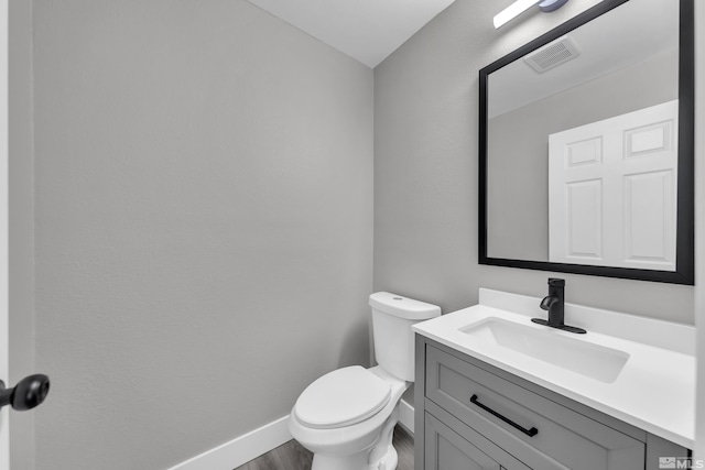 bathroom featuring hardwood / wood-style floors, vanity, and toilet