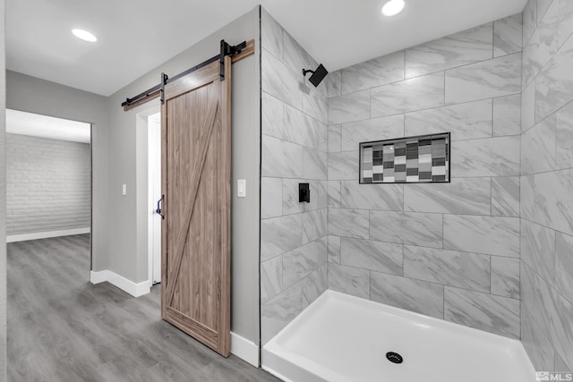 bathroom featuring hardwood / wood-style floors and tiled shower