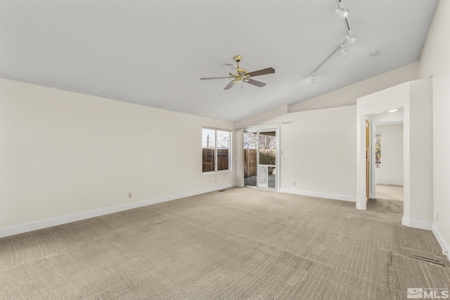 unfurnished room with light carpet, rail lighting, ceiling fan, and lofted ceiling