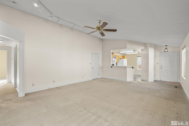 unfurnished living room with rail lighting, light colored carpet, ceiling fan, and lofted ceiling