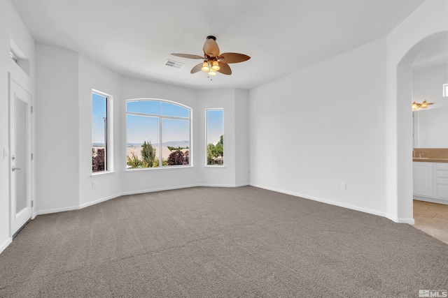 carpeted spare room with ceiling fan