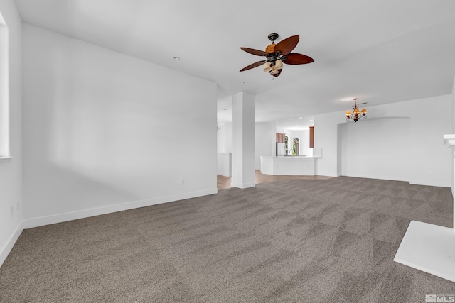 unfurnished living room featuring ceiling fan with notable chandelier and carpet floors