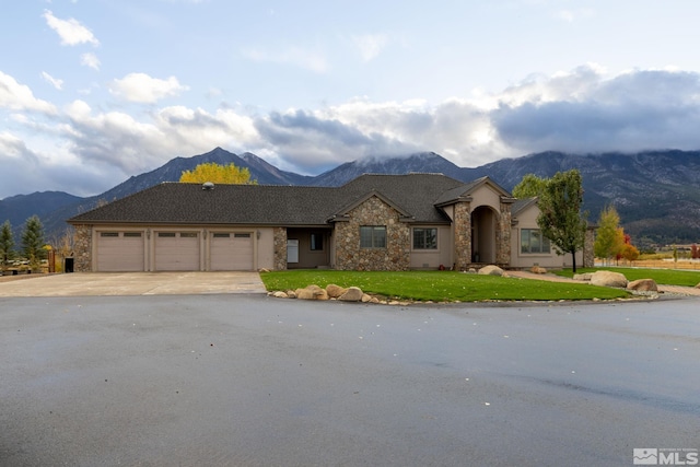 view of front facade featuring a mountain view, a garage, and a front yard