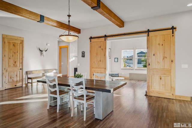 dining room with a barn door, dark hardwood / wood-style flooring, and beam ceiling