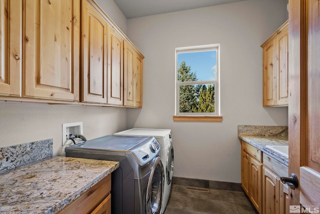 laundry room featuring washer and dryer, cabinets, dark tile patterned floors, and sink