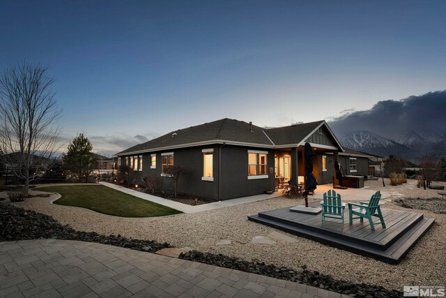 back house at dusk featuring a deck with mountain view