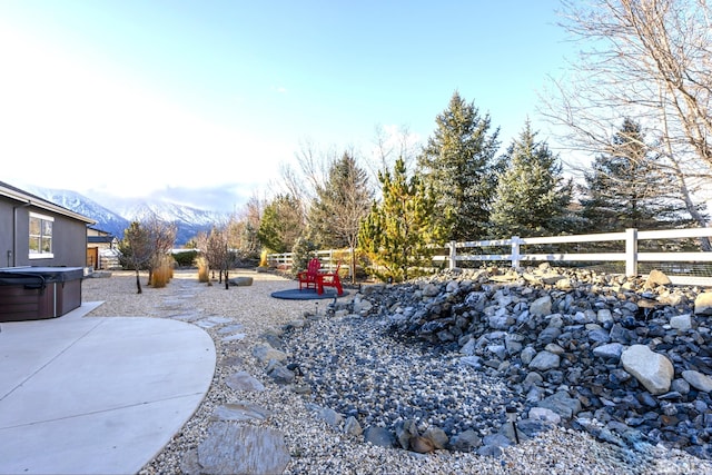 view of yard with a mountain view, a patio, and a hot tub