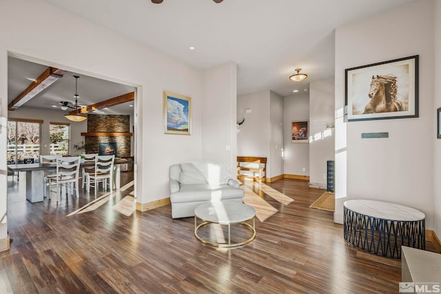 living room featuring beamed ceiling, dark hardwood / wood-style floors, and ceiling fan