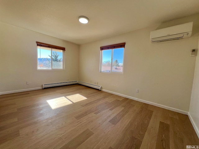 unfurnished room with a wall unit AC, baseboard heating, a wealth of natural light, and light hardwood / wood-style flooring