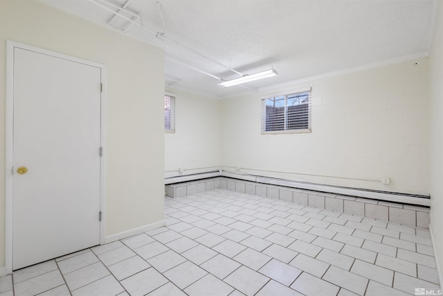 basement featuring light tile patterned flooring and a textured ceiling