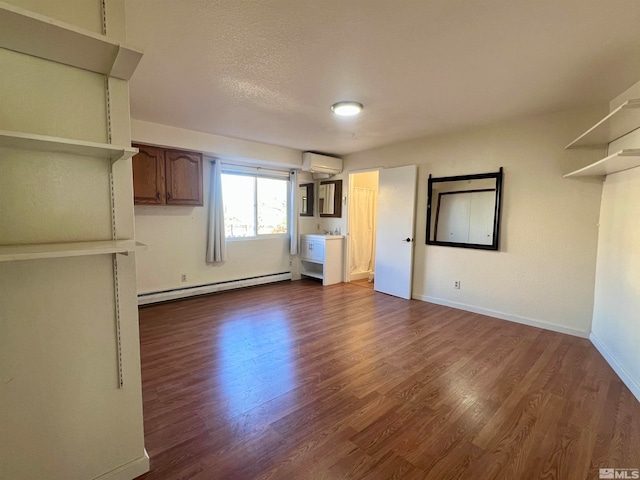 unfurnished living room with dark hardwood / wood-style flooring, an AC wall unit, a textured ceiling, and a baseboard radiator