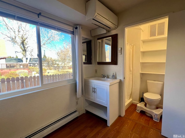 bathroom featuring a shower with curtain, vanity, a wall unit AC, baseboard heating, and hardwood / wood-style flooring