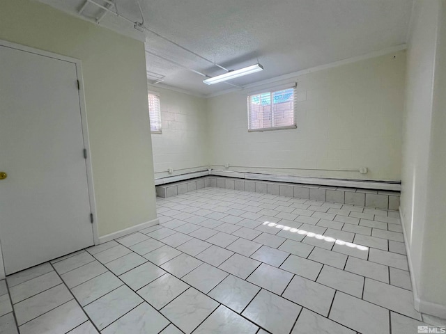 basement featuring light tile patterned flooring, a healthy amount of sunlight, and a textured ceiling