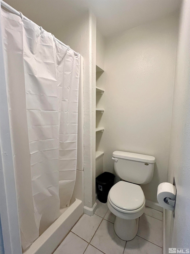 bathroom featuring tile patterned flooring, a shower with curtain, and toilet