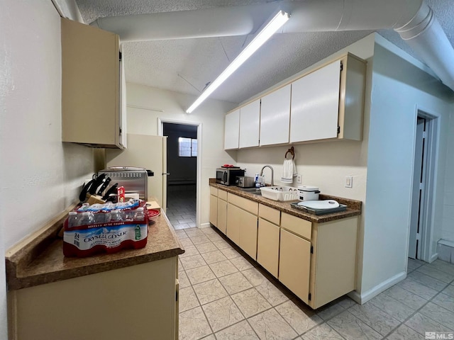 kitchen with cream cabinetry and a textured ceiling