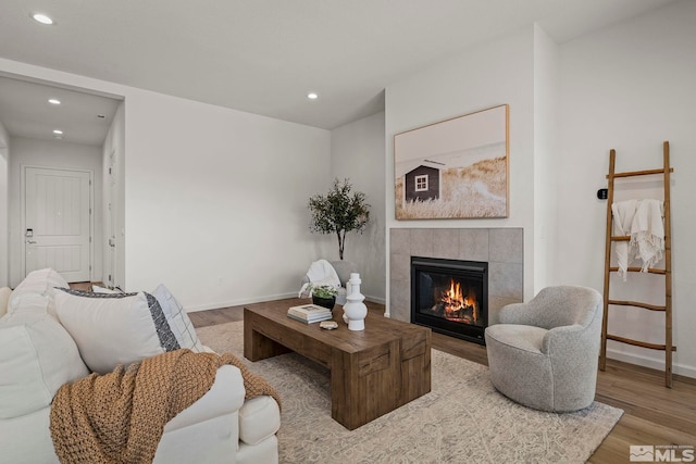 living room with light hardwood / wood-style flooring and a tiled fireplace