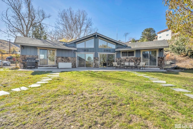 back of property with a lawn and a patio