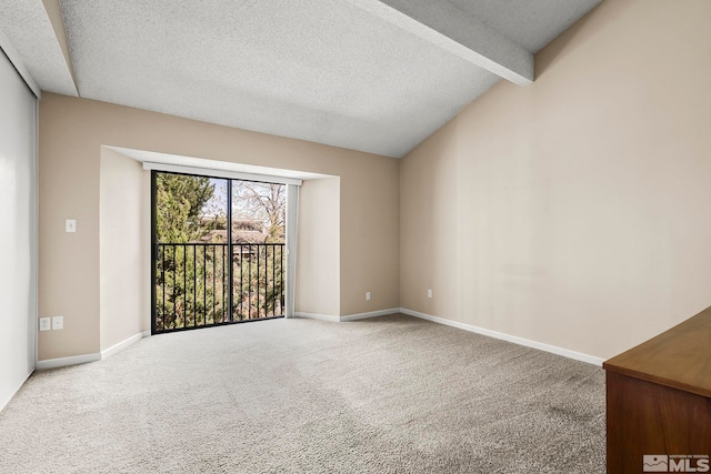 carpeted empty room featuring a textured ceiling and vaulted ceiling with beams