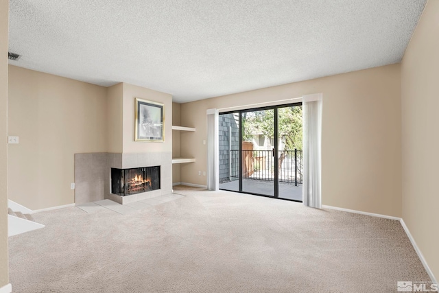 unfurnished living room with light carpet, a textured ceiling, and a fireplace