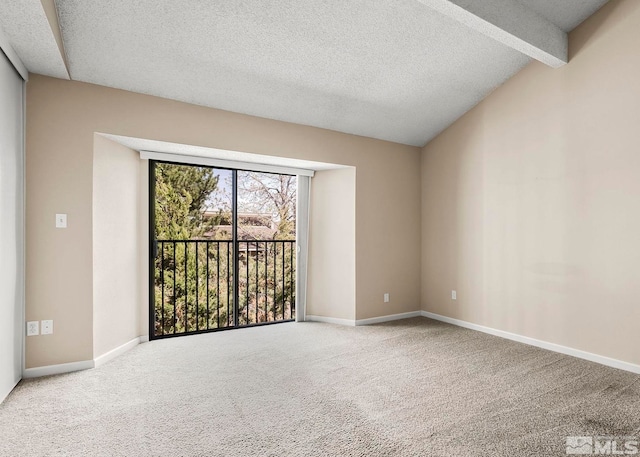 spare room featuring a textured ceiling, carpet floors, and vaulted ceiling with beams