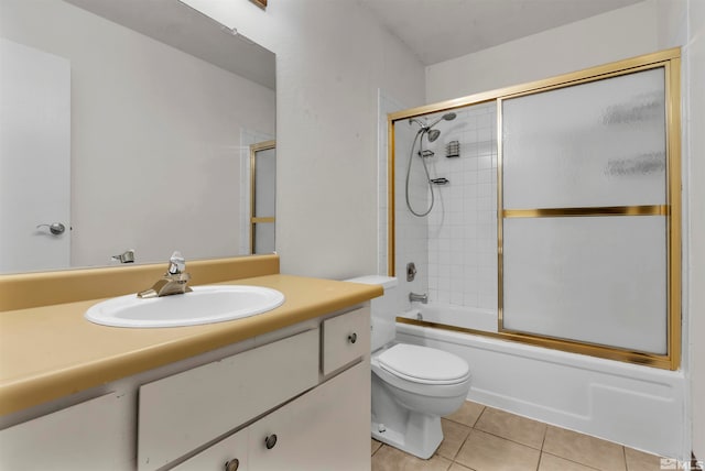 full bathroom featuring tile patterned flooring, vanity, toilet, and combined bath / shower with glass door