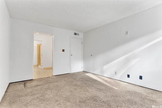 carpeted spare room featuring a textured ceiling