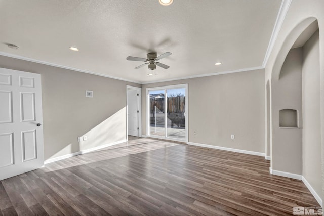 spare room with a textured ceiling, ceiling fan, dark hardwood / wood-style flooring, and crown molding