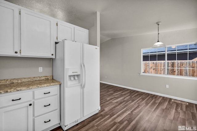 kitchen with white fridge with ice dispenser, hanging light fixtures, dark hardwood / wood-style flooring, lofted ceiling, and white cabinets