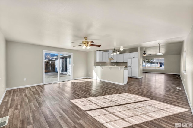 unfurnished living room with ceiling fan and dark hardwood / wood-style flooring