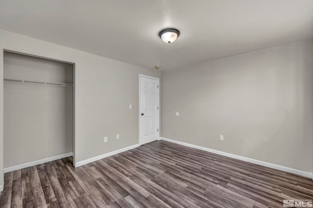 unfurnished bedroom featuring dark hardwood / wood-style flooring and a closet