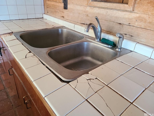 room details featuring tile countertops and sink