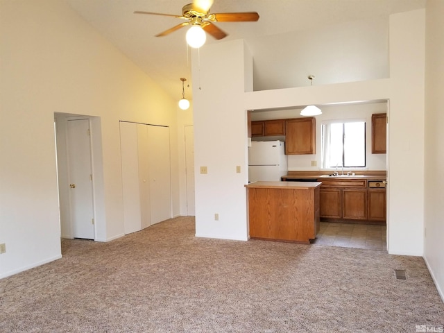 kitchen with light carpet, sink, white fridge, and high vaulted ceiling