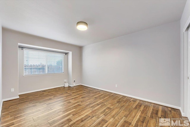 empty room with hardwood / wood-style flooring