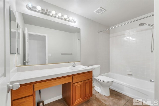 full bathroom with tiled shower / bath, tile patterned flooring, vanity, and toilet