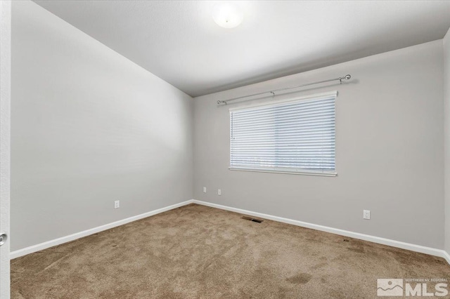 empty room featuring carpet and lofted ceiling