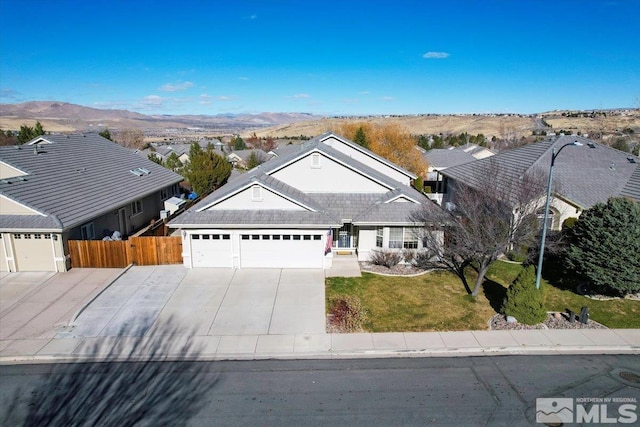 ranch-style home featuring a front yard, a mountain view, and a garage