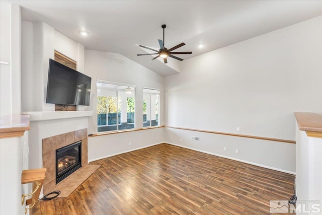 unfurnished living room with a tile fireplace, ceiling fan, dark hardwood / wood-style flooring, and lofted ceiling