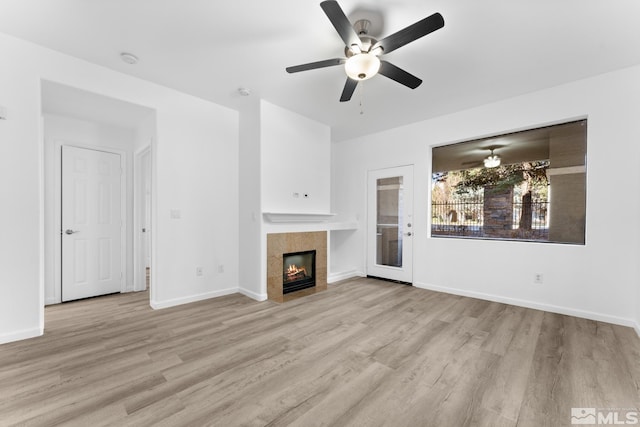 unfurnished living room with ceiling fan, light wood-type flooring, and a fireplace