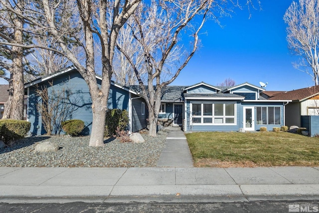 ranch-style house with a sunroom and a front yard