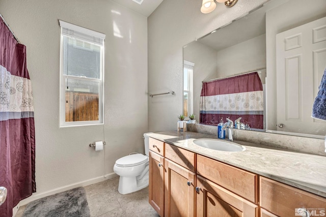 bathroom featuring tile patterned floors, plenty of natural light, toilet, and vanity