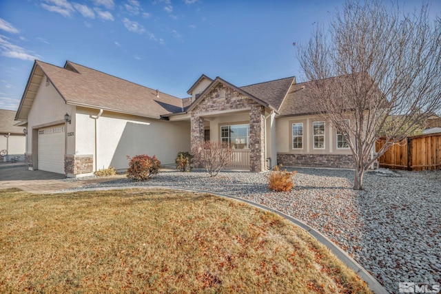 view of front of home featuring covered porch, a garage, and a front lawn