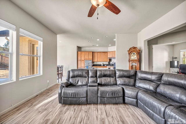 living room featuring light wood-type flooring and ceiling fan