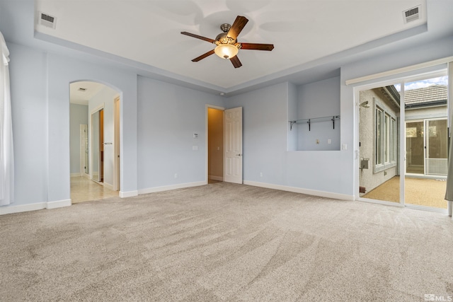 unfurnished room featuring light carpet, a raised ceiling, and ceiling fan