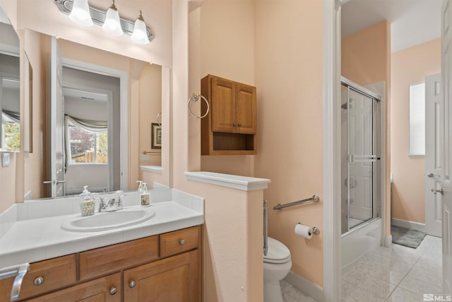 full bathroom featuring vanity, bath / shower combo with glass door, tile patterned floors, and toilet