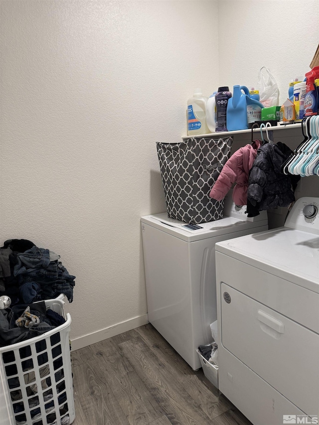 washroom with washing machine and clothes dryer and dark wood-type flooring