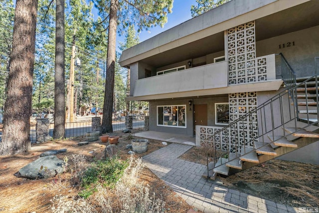 entrance to property featuring a patio area and a balcony